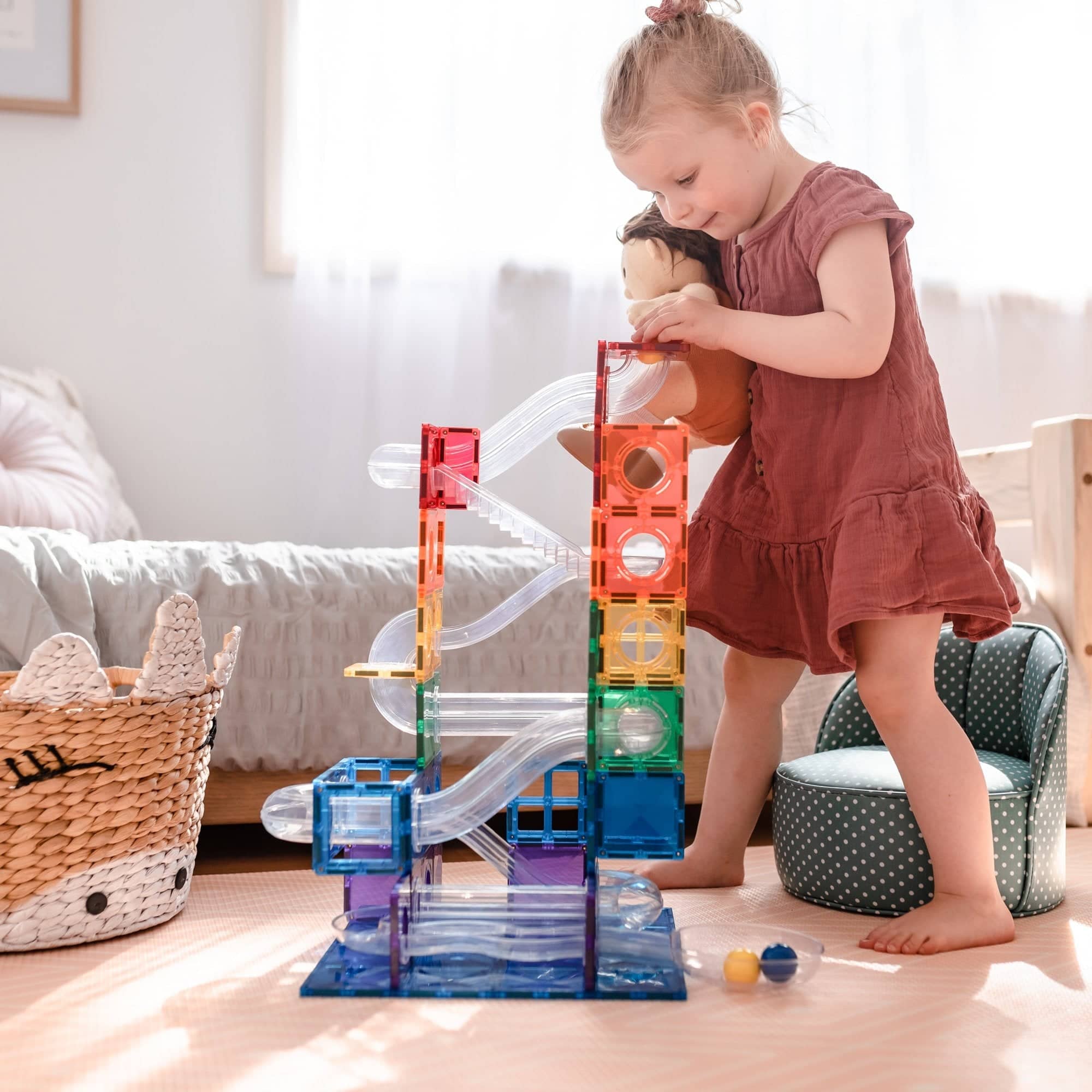 Kleines Mädchen spielt mit buntem Bauklötze & Konstruktionsspielzeug im hellen Kinderzimmer
