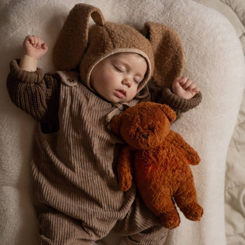 Schlafendes Baby mit weichem Kuscheltier im braunen Outfit Kuscheltiere mit Geräuschen zum Beruhigen und Einschlafen