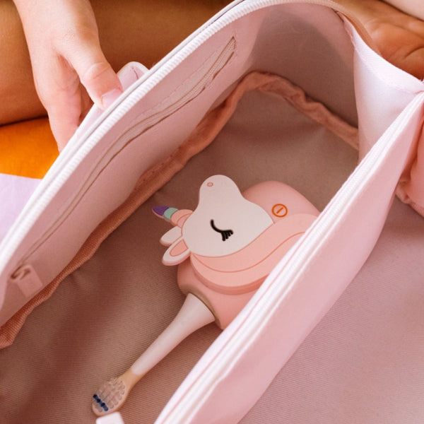 Einhorn-Schallzahnbürste in einem rosa Kulturbeutel