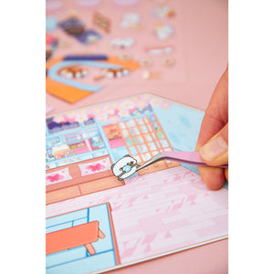 Hand setzt mit der Pinzette einen Mini-Sticker in die Szene