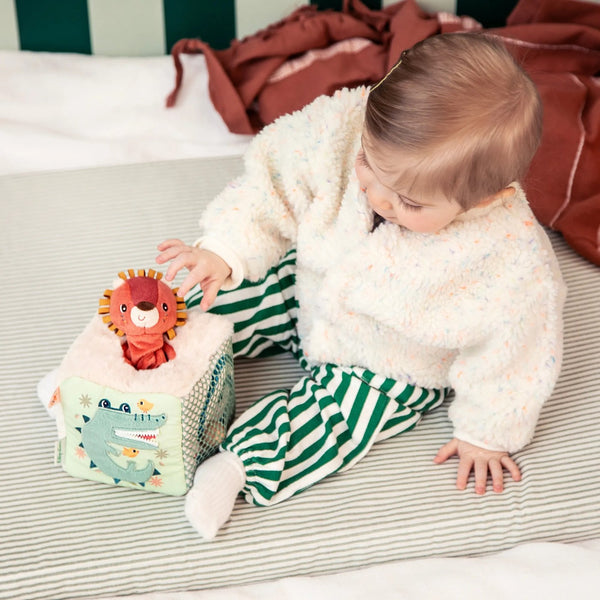 Baby spielt mit dem Activity-Würfel Löwe Jack von Lilliputiens