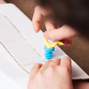 Kind benutzt Satz mit 12 Miniwerkzeugen von Makedo zum Schrauben in Kartonmaterial