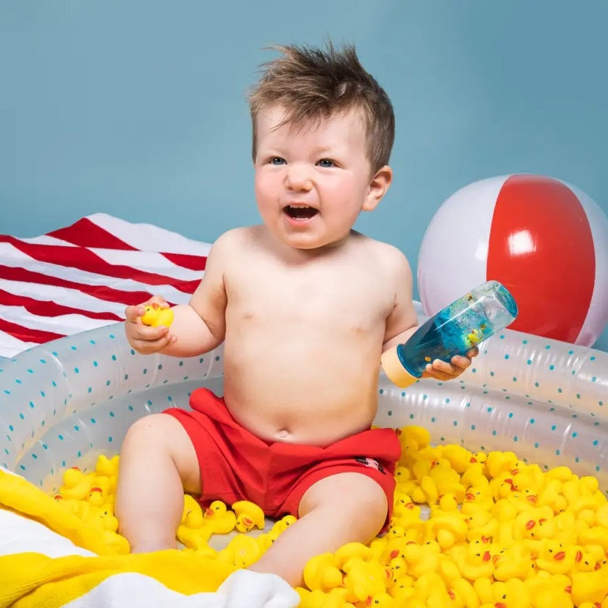 Sensorikflasche für Kinder mit bunten Schwimmspielzeugen und blauem Wasser für haptische Erkundung
