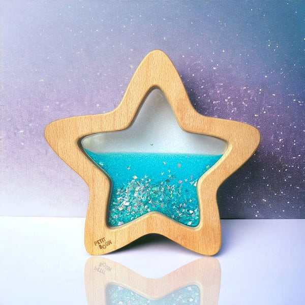 Sensorischer Stern leuchtet im Dunkeln aus Holz mit glitzerndem, blauem Flüssigkeitsinhalt