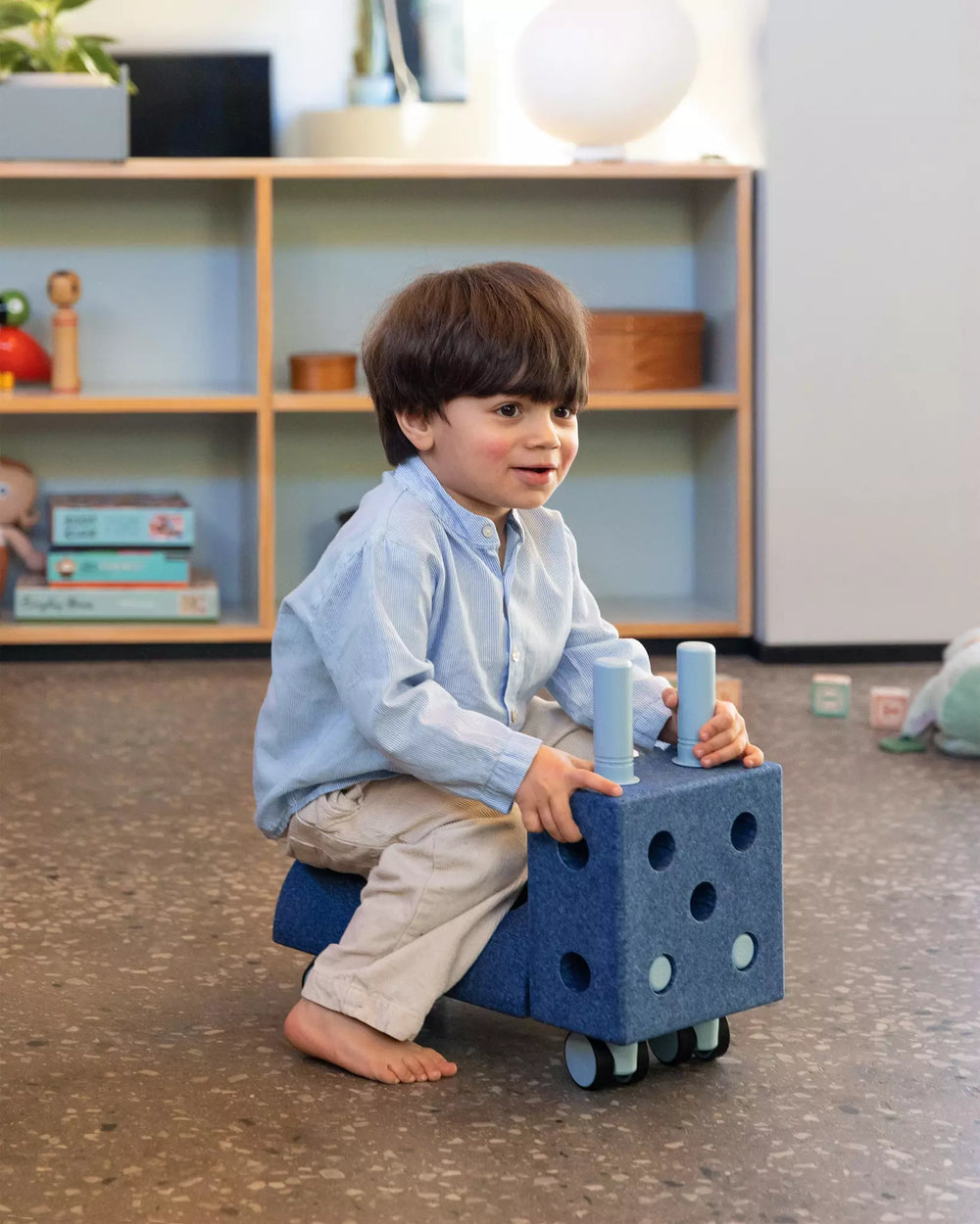 Kinder spielen mit MODU Klocki auf einem Blauen Spielzeug mit Rollen, ideal für kreative Aktivitäten